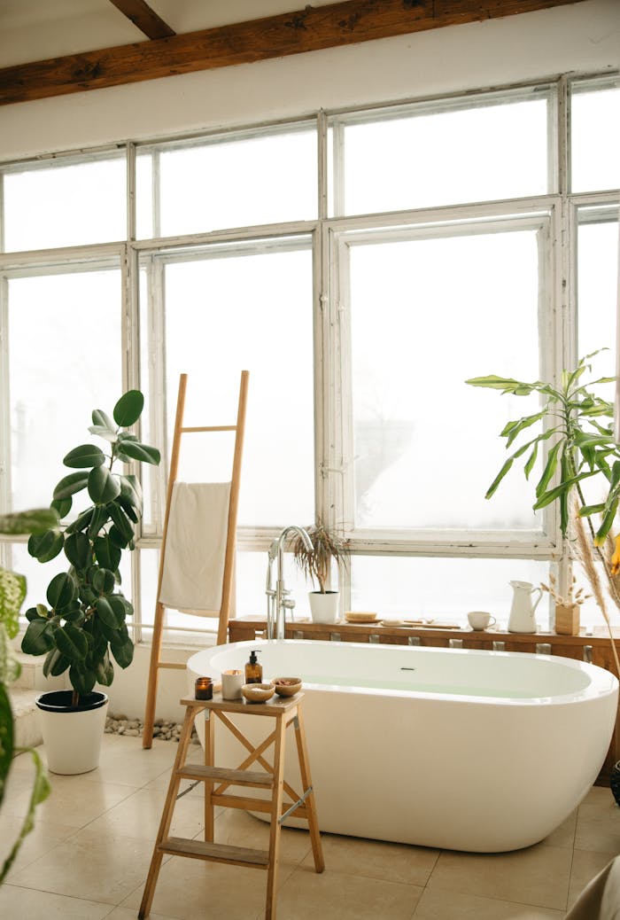 Bright bathroom featuring a bathtub and lush green plants for a relaxing vibe.
